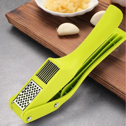 2-in-1 garlic press and slicer in vibrant green color on wooden cutting board with garlic.