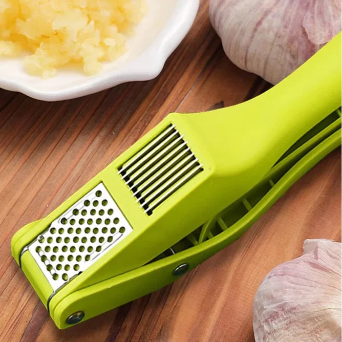2-in-1 garlic press and slicer in vibrant green on wooden surface with garlic cloves and minced garlic.