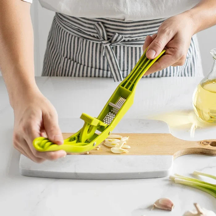Person using a 2-in-1 garlic press and slicer on a wooden cutting board.