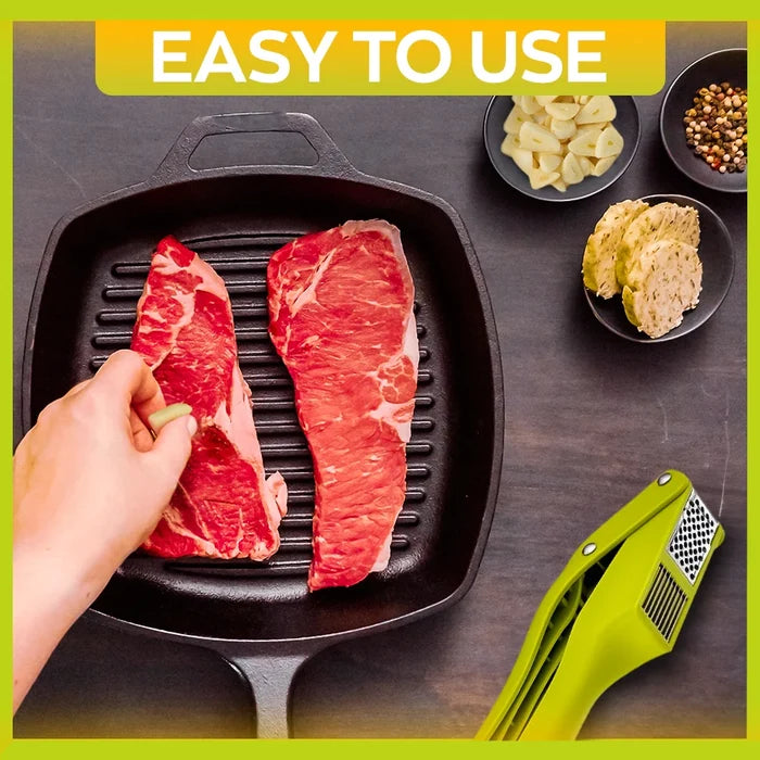2-in-1 garlic press and slicer beside steaks and seasonings in a kitchen setting, showcasing easy cooking.