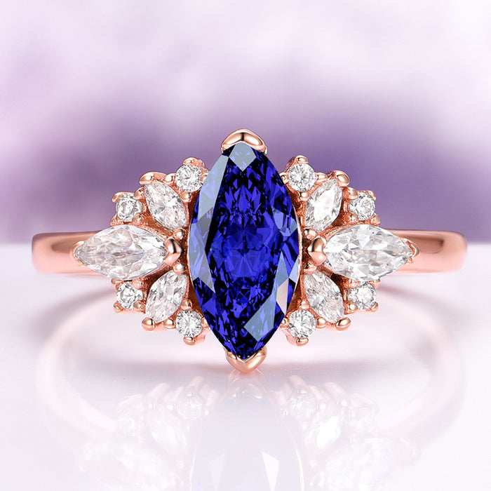 Adeline Marquise Cut Flower Blue Sapphire Engagement Ring in 14K Solid Rose Gold by Aquamarise Gold, featuring marquise blue sapphire with floral diamond accents on a rose gold band.
