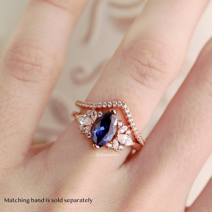 Adeline Marquise Cut Flower Blue Sapphire Engagement Ring in 14K Solid Rose Gold by Aquamarise Gold featuring marquise blue sapphire with floral simulated diamonds on hand.