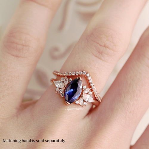 Adeline Marquise Cut Flower Blue Sapphire Engagement Ring in 14K Solid Rose Gold by Aquamarise Gold featuring marquise blue sapphire with floral simulated diamonds on hand.