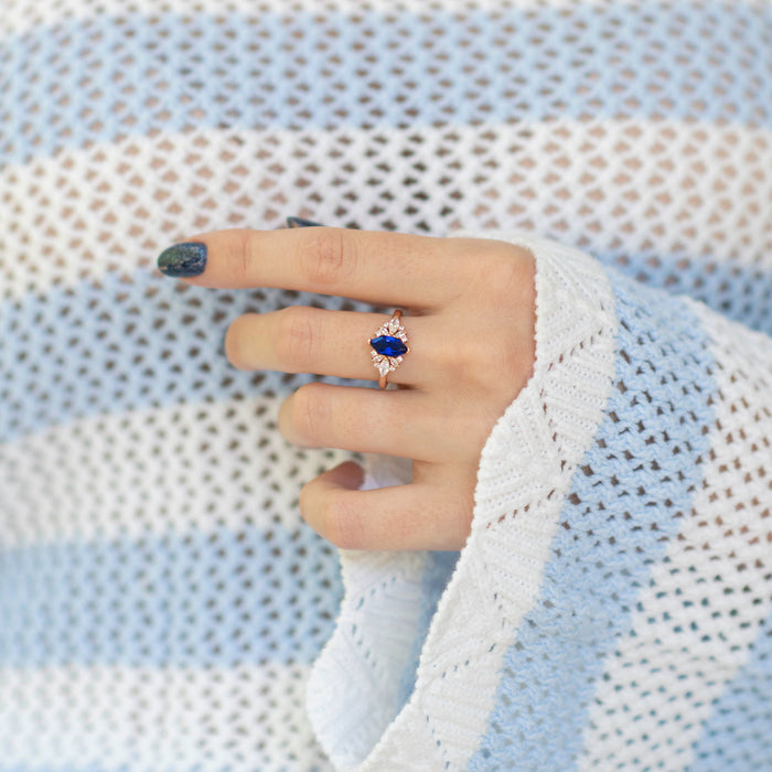 Adeline Marquise Cut Flower Blue Sapphire Engagement Ring in 14K Solid Rose Gold by Aquamarise Gold, showcasing a marquise blue sapphire with floral-inspired design on a hand.