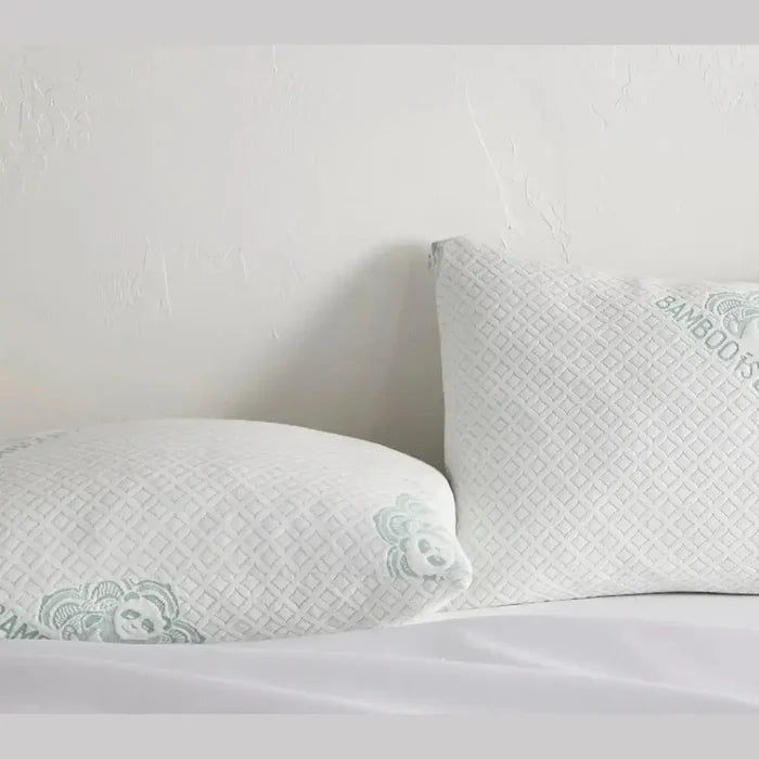 Adjustable bamboo cooling pillow with shredded memory foam on a bed, perfect for all sleeping positions.