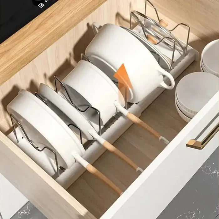 Adjustable pot and pan organizer with upright cookware storage in a kitchen drawer.