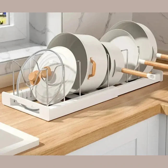 Adjustable pot and pan organizer with multiple cookware pieces stored upright on a kitchen counter.