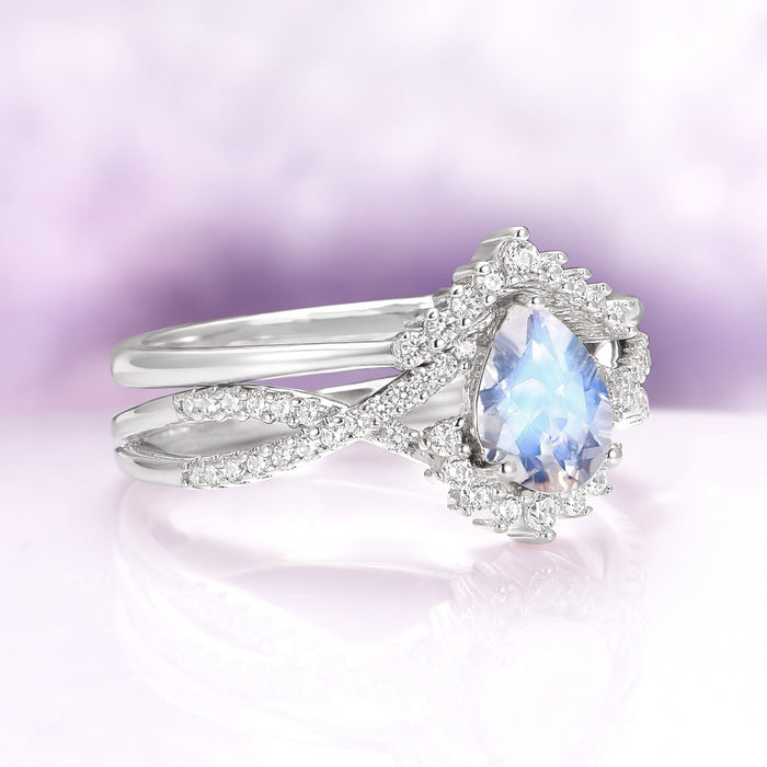 Alice Rainbow Moonstone Couples Ring Set by Aquamarise featuring a pear-shaped moonstone with diamond accents on an intertwined sterling silver band in a fantasy-inspired design.