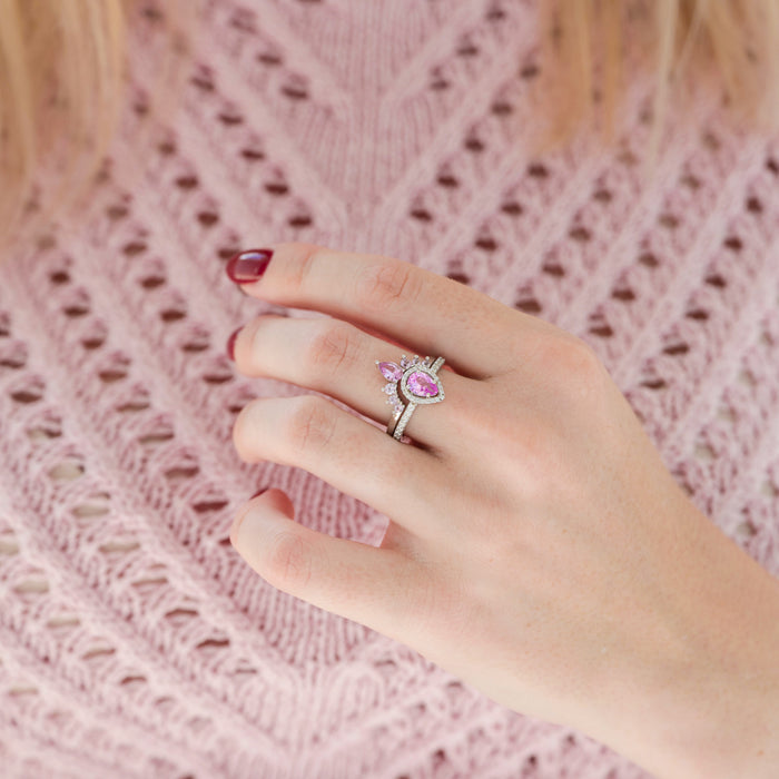 Amy Pink Sapphire Engagement Ring Set in Sterling Silver by Aquamarise featuring a pear-cut pink sapphire with delicate diamond accents in a vintage-inspired design on a hand.