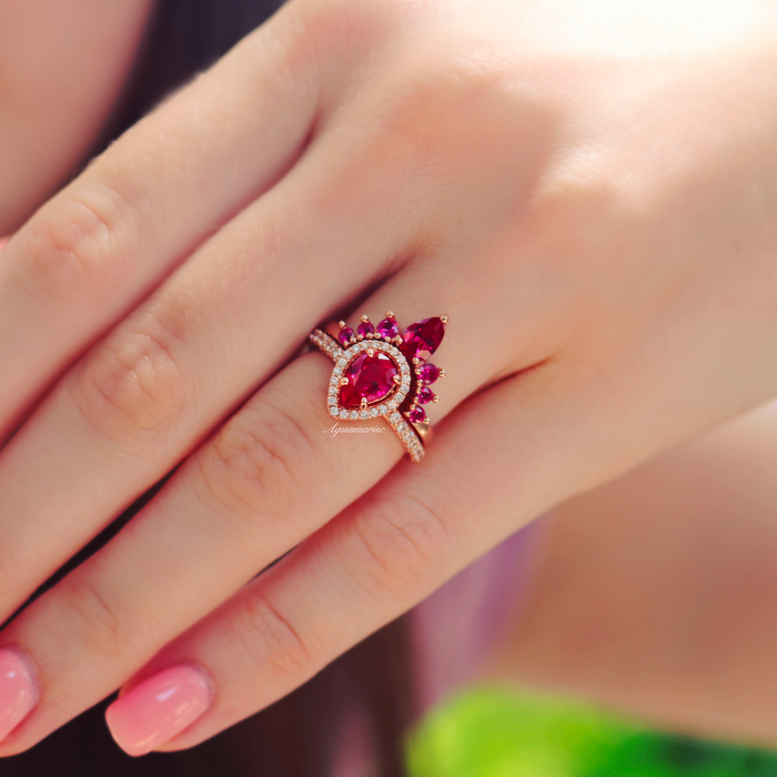 Amy Teardrop Lab-Grown Ruby Ring Set in 14K Rose Gold Vermeil by Aquamarise, featuring a pear-shaped ruby surrounded by accent stones on a rose gold vermeil band, worn on a hand.