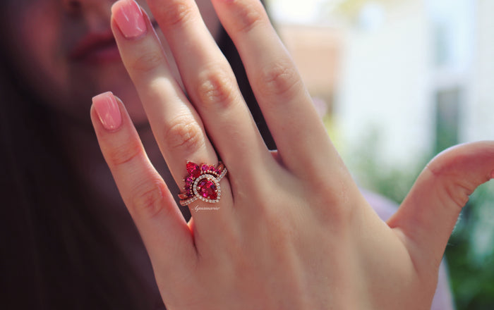 Amy Teardrop Lab-Grown Ruby Ring Set in 14K Rose Gold Vermeil by Aquamarise, featuring pear-cut rubies and accent stones on rose gold vermeil bands worn on a hand.