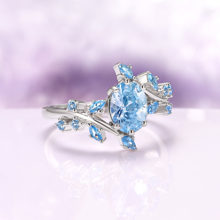 Aquamarine Fairy Leaf Engagement Ring in 14K White Gold by Aquamarise Gold, featuring an oval ice-blue aquamarine center stone surrounded by delicate leaf-shaped accents on a polished 14K white gold band, part of collections including Solid Gold Engagement Rings, March Birthstone Jewelry, and Nature-Inspired Engagement Rings.