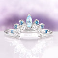 Aquamarine & Swiss Topaz Stacking Ring in Sterling Silver by Aquamarise, featuring a curved sterling silver band adorned with a marquise aquamarine center stone and round Swiss blue topaz and clear gemstones, ideal for layering or wedding sets.