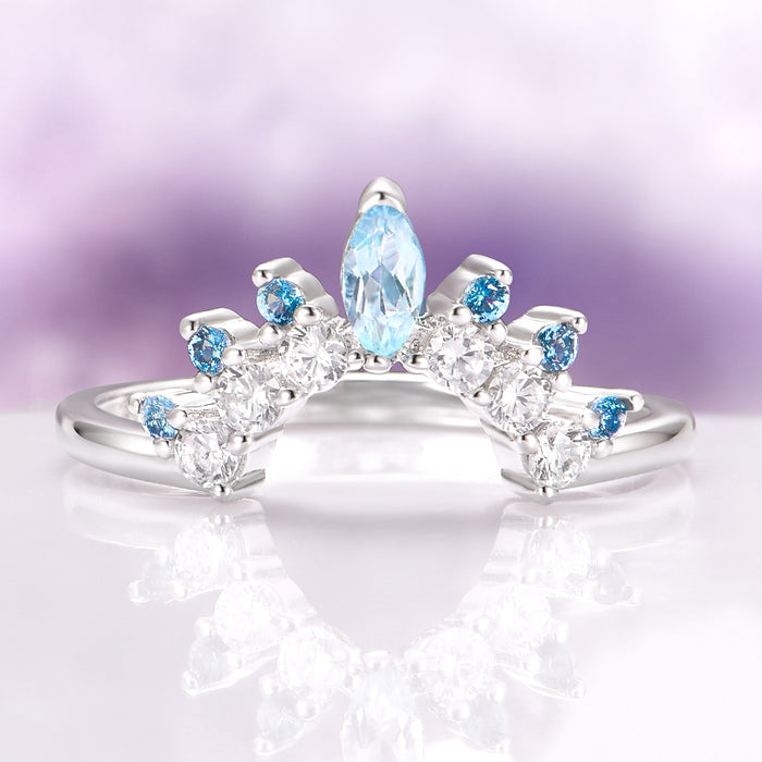 Aquamarine & Swiss Topaz Stacking Ring in Sterling Silver by Aquamarise, featuring a curved sterling silver band adorned with a marquise aquamarine center stone and round Swiss blue topaz and clear gemstones, ideal for layering or wedding sets.