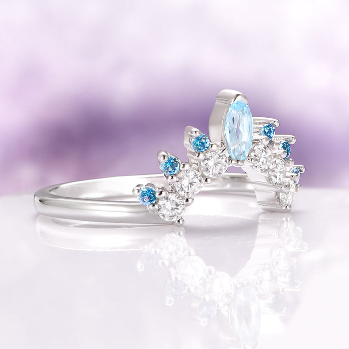Aquamarine & Swiss Topaz Stacking Ring in Sterling Silver by Aquamarise, featuring a curved sterling silver band accented with a marquise aquamarine center stone and alternating round Swiss blue topaz and clear gemstones, ideal for layering in women’s sterling silver wedding bands and birthstone jewelry collections.