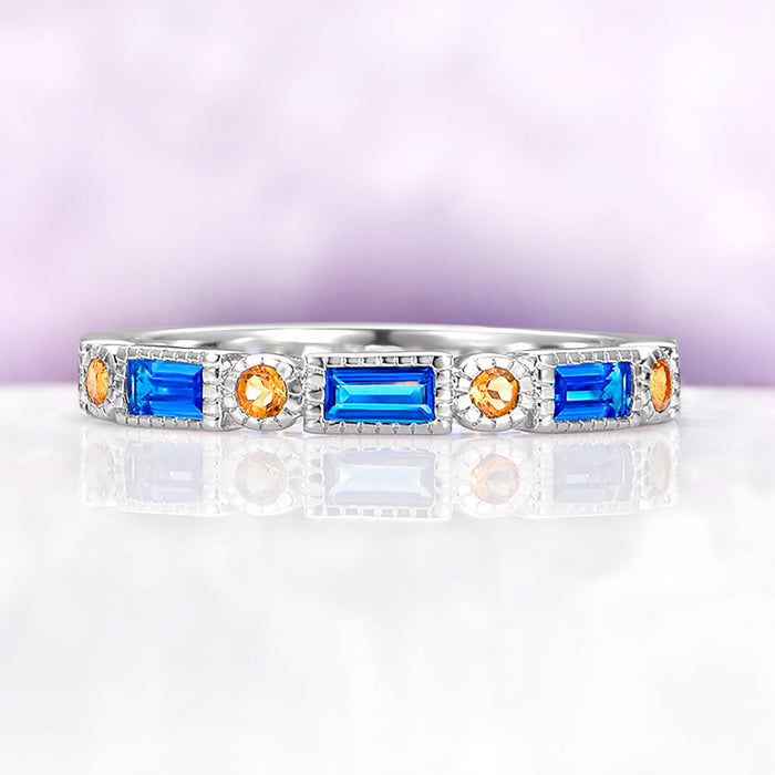Art Deco Blue Topaz & Citrine Ring in Sterling Silver by Aquamarise, featuring emerald cut blue topaz and round citrine gemstones set in a detailed sterling silver band.