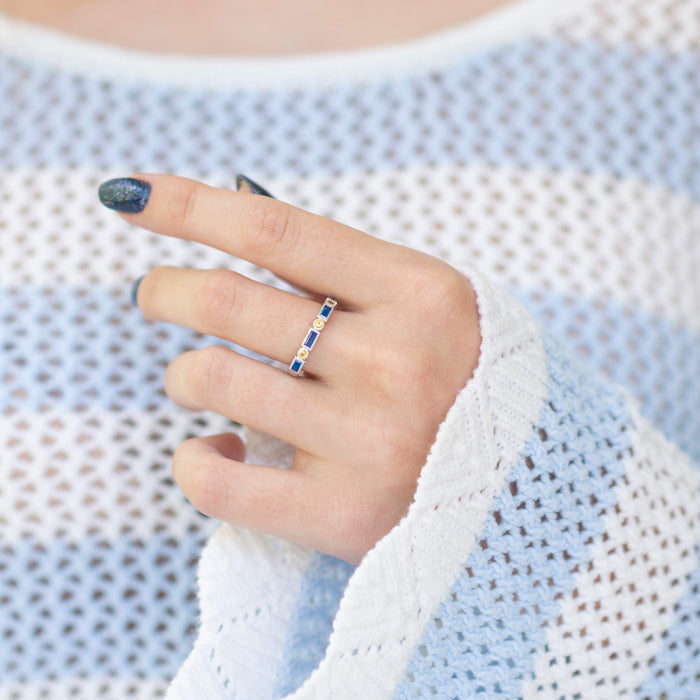 Ari Art Deco Blue Topaz & Citrine Ring- Sterling Silver by Aquamarise, featuring emerald cut blue topaz and citrine stones on a delicate sterling silver band worn on a hand.