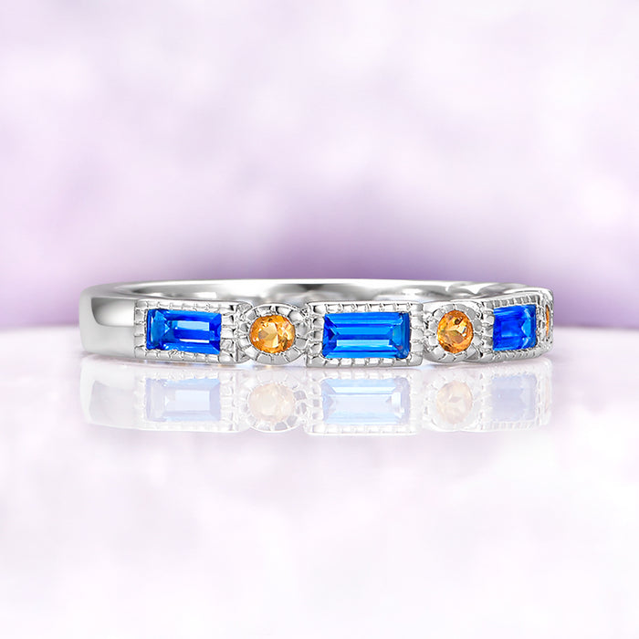 Art Deco Blue Topaz & Citrine Ring in Sterling Silver by Aquamarise, showcasing emerald cut Swiss blue topaz and round citrine stones in a minimalist sterling silver band.