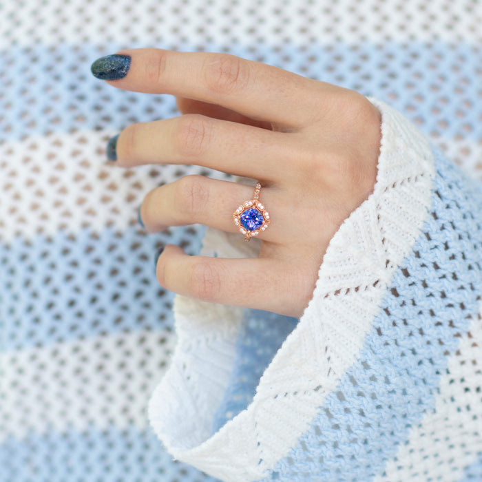 Tanzanite Ring- 14K Rose Gold Vermeil by Aquamarise featuring a vibrant violet-blue cushion-cut stone with a sparkling vintage-inspired halo on a delicate rose gold band.