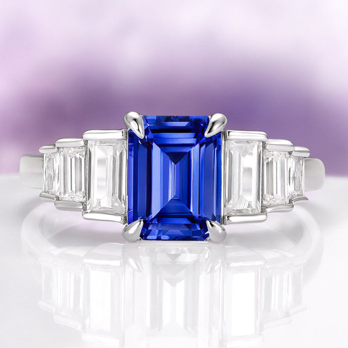 Art Deco Emerald Cut Blue Sapphire Engagement Ring in Sterling Silver by Aquamarise, featuring a deep blue emerald-cut sapphire center stone accented with tapered baguette clear gemstones on a polished sterling silver band, ideal for Sterling Silver Rings, September Birthstone Jewelry, Engagement Rings for Women, and Meaningful Jewelry Gifts collections.