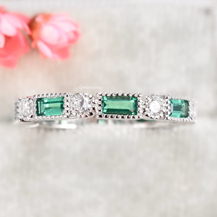 Ari Art Deco Emerald Wedding Band- Sterling Silver by Aquamarise, featuring alternating simulated emerald baguettes and round simulated diamonds with milgrain detailing on a silver band.