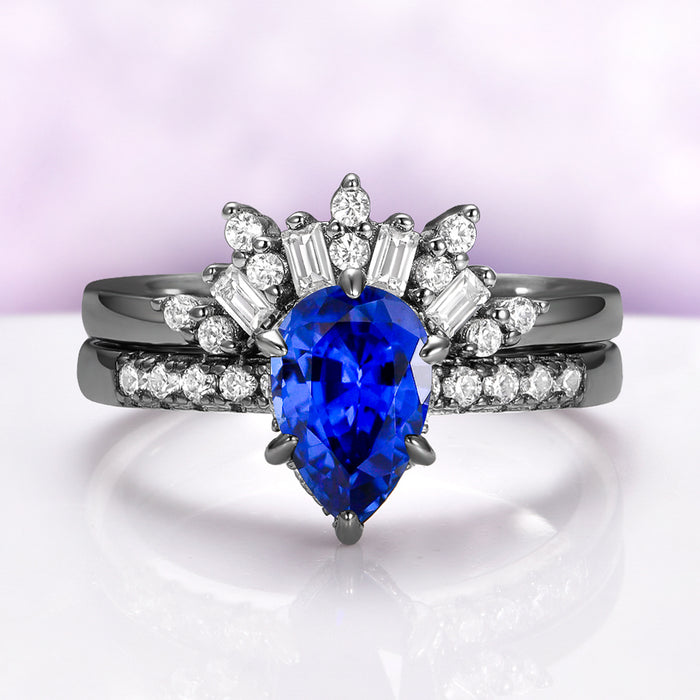 Art Deco Pear Blue Sapphire Ring Set in Black Ruthenium by Aquamarise featuring a pear-shaped blue sapphire with diamond accents on elegant black ruthenium bands.