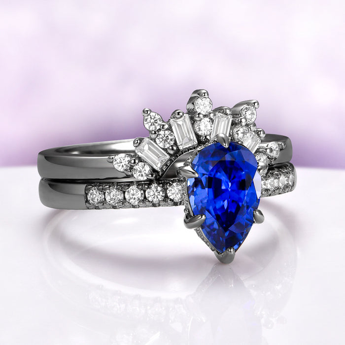 Art Deco Pear Blue Sapphire Ring Set in Black Ruthenium by Aquamarise, featuring a pear-shaped blue sapphire with baguette and round diamonds on sleek black ruthenium bands.