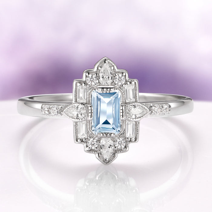 Art Deco Mosaic Aquamarine Engagement Ring in 14K White Gold by Aquamarise Gold, featuring an emerald-cut ice blue aquamarine surrounded by geometric diamond accents on a polished white gold band, part of Solid Gold Engagement Rings and March Birthstone Jewelry collections.