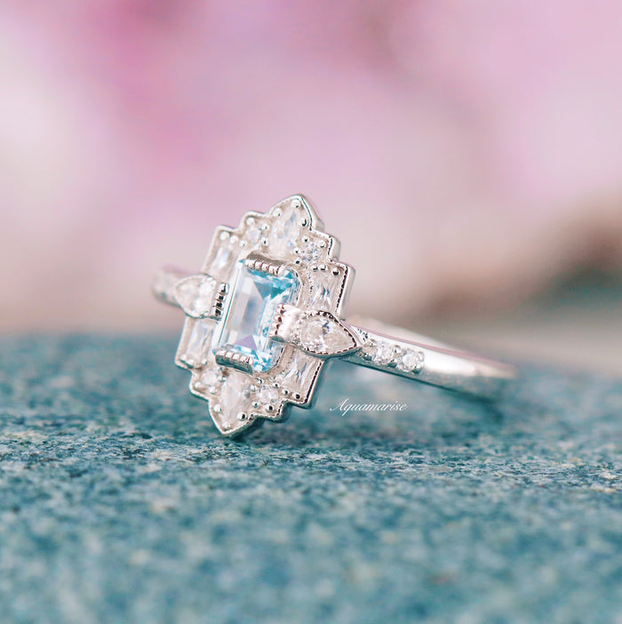 Art Deco Mosaic Aquamarine Engagement Ring in 14K White Gold featuring an ice blue emerald-cut aquamarine centerpiece framed by intricate geometric diamond accents on a finely detailed polished band by Aquamarise Gold.