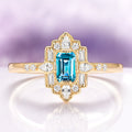 Art Deco London Blue Topaz Engagement Ring in 14K Solid Yellow Gold by Aquamarise Gold, featuring an emerald-cut blue topaz with diamond accents in a vintage-inspired design.