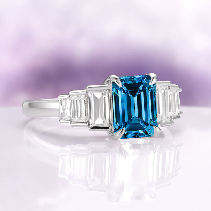 Art Deco Natural London Blue Topaz Engagement Ring in Sterling Silver by Aquamarise featuring an emerald-cut deep blue topaz center stone flanked by tapered baguette clear gemstones on a polished sterling silver band, part of Sterling Silver Rings, November Birthstone, Engagement Rings for Women, Birthstone Jewelry, and New Arrivals collections.