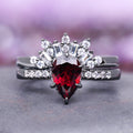 Art Deco Natural Red Garnet Ring Set- Black Ruthenium (Vampire Inspired) by Aquamarise features a pear-shaped red garnet centerpiece with surrounding white gemstones on a black ruthenium sterling silver band, part of January Birthstone Jewelry and Fantasy-Inspired Engagement Rings collections.