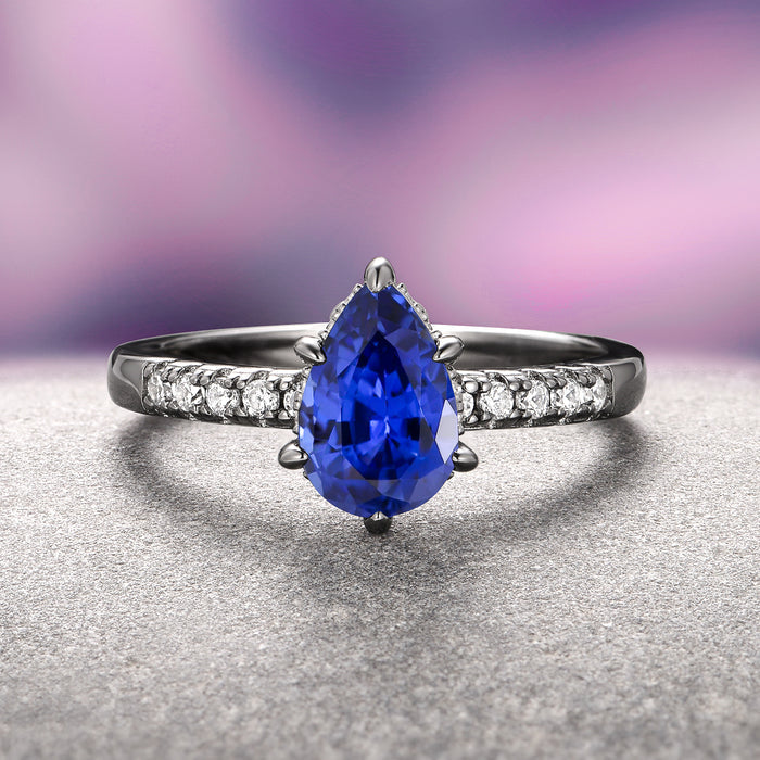 Art Deco Blue Sapphire Ring Set- Black Ruthenium by Aquamarise showcases a pear-shaped blue sapphire centerpiece with a black ruthenium over sterling silver band accented by sparkling white gemstones, part of September Birthstone Jewelry and Fantasy-Inspired Engagement Rings collections.