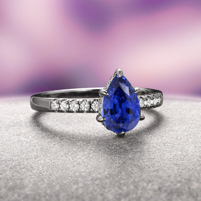 Art Deco Blue Sapphire Ring Set- Black Ruthenium by Aquamarise features a vivid teardrop blue sapphire centerpiece set in black ruthenium over sterling silver, accented with sparkling white gemstones, perfect for September Birthstone Jewelry and alternative engagement rings.