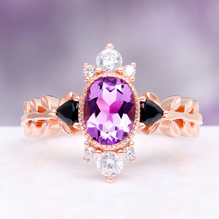 Aurelia Amethyst & Black Onyx Leaf Engagement Ring in 14K Solid Rose Gold by Aquamarise Gold, featuring an oval amethyst center flanked by black onyx and leaf-inspired band detailing.