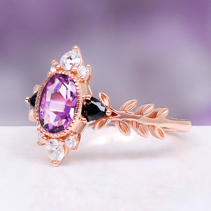 Aurelia Amethyst & Black Onyx Leaf Engagement Ring in 14K Solid Rose Gold by Aquamarise Gold, featuring an oval amethyst, black onyx accents, and a detailed rose gold leaf-inspired band.