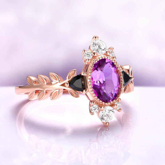 Aurelia Amethyst & Black Onyx Leaf Engagement Ring in 14K Solid Rose Gold by Aquamarise Gold, featuring an oval amethyst, black onyx accents, sparkling white gemstones, and a leaf-inspired band.