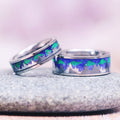 Aurora Borealis Forest Couples Ring Set- Northern Lights & Trees featuring matching silver bands with vibrant blue and green northern lights inlay resembling a forest silhouette, crafted by Aquamarise for nature-inspired couples rings.