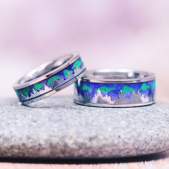Aurora Borealis Forest Couples Ring Set- Northern Lights & Trees featuring matching silver bands with vibrant blue and green northern lights inlay resembling a forest silhouette, crafted by Aquamarise for nature-inspired couples rings.