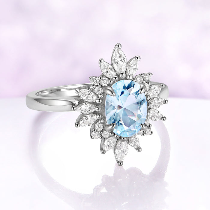 Aurora Oval Halo Aquamarine Ring in Sterling Silver by Aquamarise, featuring a 1.4 carat lab-created oval aquamarine surrounded by marquise-cut simulated diamond petals.