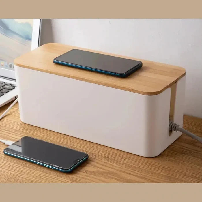 Bamboo cable organizer box on a desk with smartphones and a clean, minimalist design.