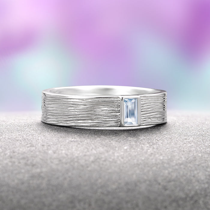 Rustic Aquamarine Wedding Band- 14K White Gold by Aquamarise Gold featuring a 5mm textured white gold band inspired by natural wood grain with a rectangular emerald-cut aquamarine, part of March Birthstone Jewelry and Nature Inspired Men’s Wedding Bands collections.