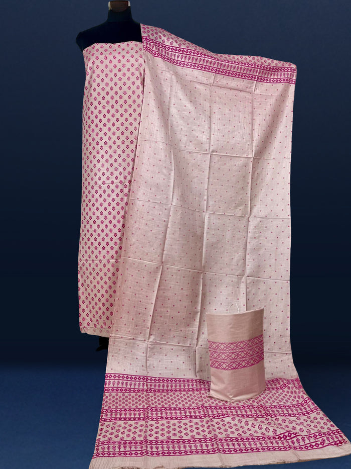 Beige katan silk unstitched suit set with small magenta floral hand block print, linear geometric striped borders and tasselled dupatta ends.