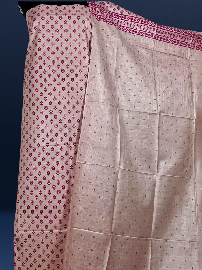 Beige katan silk unstitched suit set with small magenta floral hand block print, linear geometric striped borders and tasselled dupatta ends.