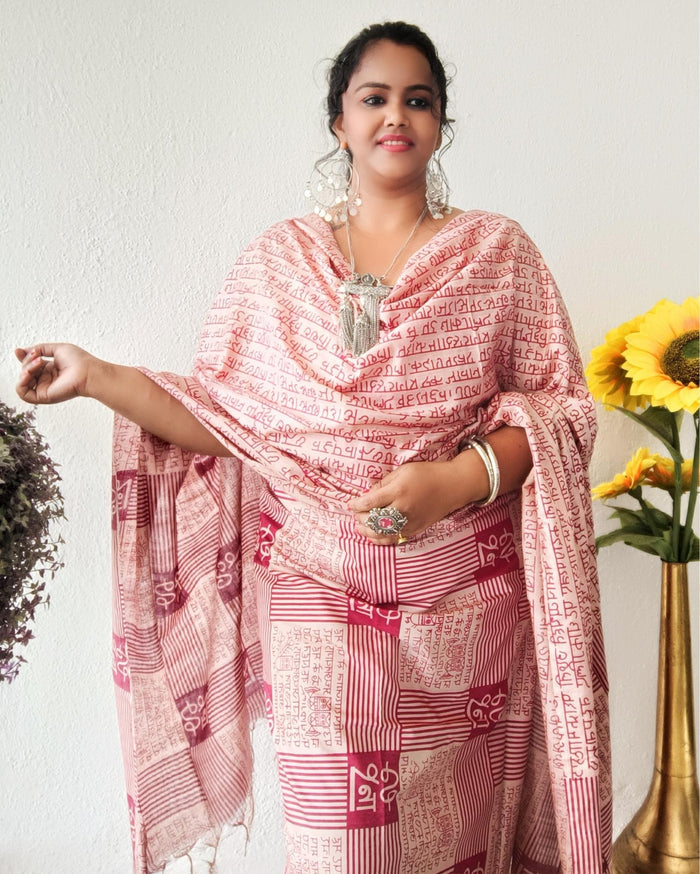 Beige Katan silk unstitched suit set block printed with panels of Sanskrit calligraphy in deep magenta, separated by linear stripes with white accents and straight, clean edges.