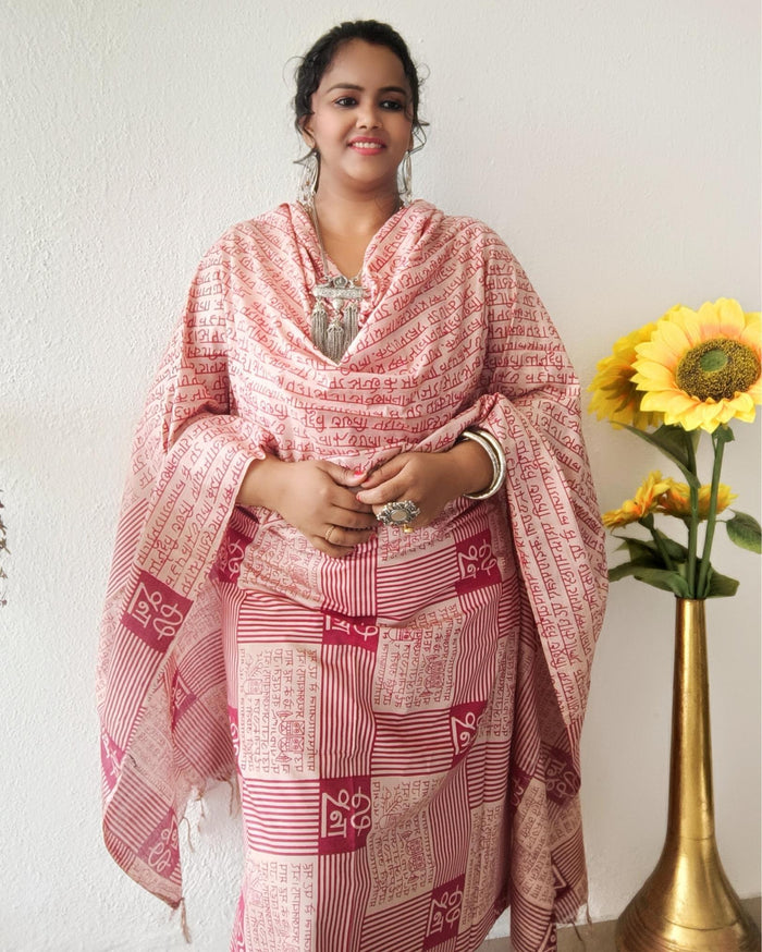 Beige Katan silk unstitched suit set block printed with panels of Sanskrit calligraphy in deep magenta, separated by linear stripes with white accents and straight, clean edges.
