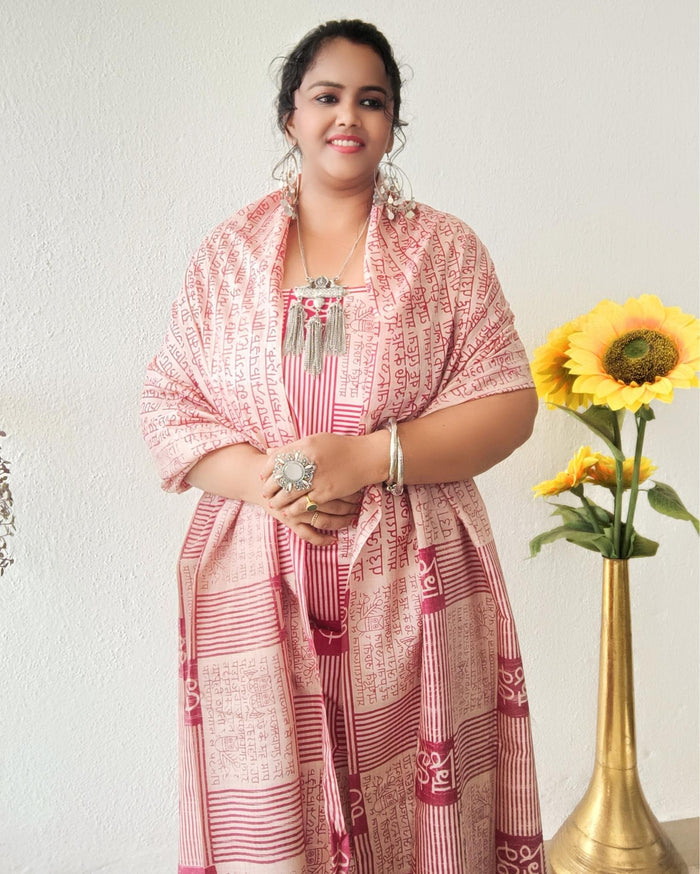 Beige Katan silk unstitched suit set block printed with panels of Sanskrit calligraphy in deep magenta, separated by linear stripes with white accents and straight, clean edges.