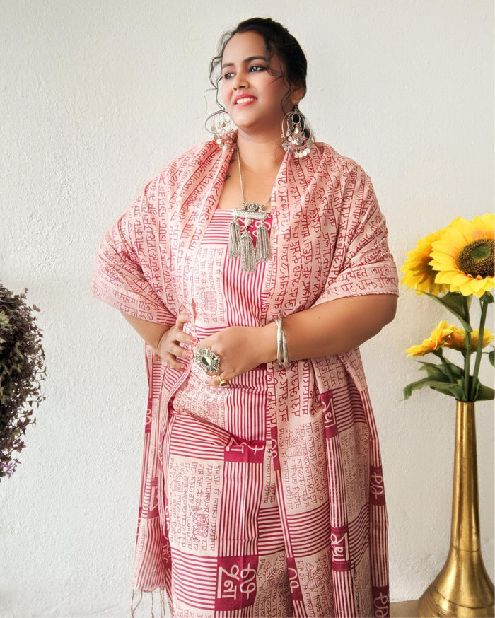 Beige Katan silk unstitched suit set block printed with panels of Sanskrit calligraphy in deep magenta, separated by linear stripes with white accents and straight, clean edges.