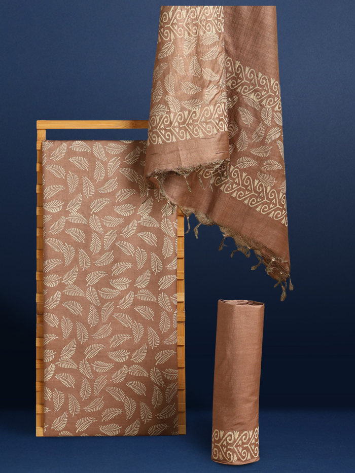 Beige and brown Katan silk unstitched suit set hand block printed with small stylised leaf motifs, the dupatta and bottom edged with a linear geometric band border.