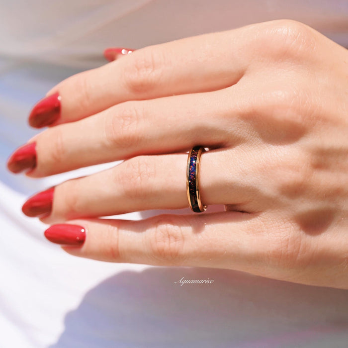 Black Fire Opal & Meteorite Couples Ring Set featuring a polished rose gold band inlaid with deep black fire opal and meteorite textures, worn on a hand with glossy red nails, crafted by Aquamarise from Matching Couples' Rings and October Birthstone collections.